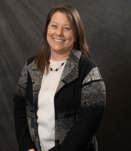 Profile photo of Andrea O'Neill against a dark background wearing a white shirt and a grey and black blazer