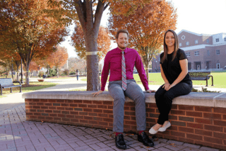 A man and a woman sitting on a bench. 