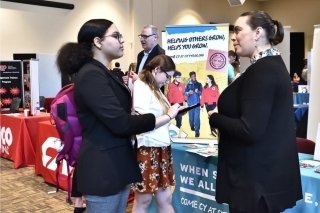 Two people talking at a vendor show. 