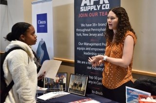 Two people talking at a vendor table. 