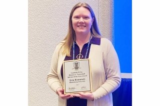 Woman holding an award. 