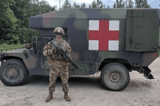 A man standing in front of military equipment. 