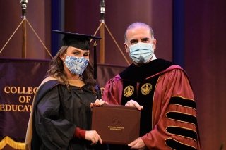 A girl receiving her diploma on graduation day. 