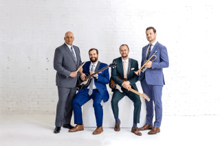 Four men holding instruments. 