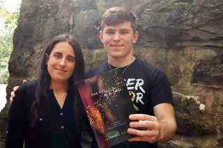 A man and a woman holding a book. 