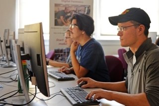 Two guys sitting at a computer. 