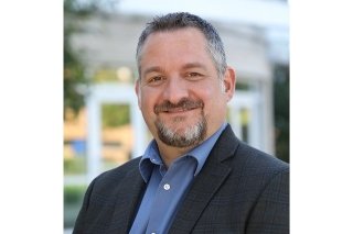 Head shot of Emanuel in a suit. 