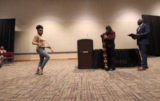 Three people practicing for graduation. 