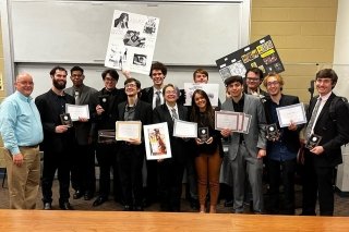 A group of people holding papers. 