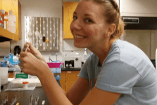 A girl standing in a kitchen. 