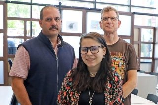 Three people standing together. 