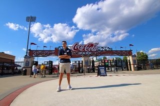 A man standing in front of a Coca Cola sign. 