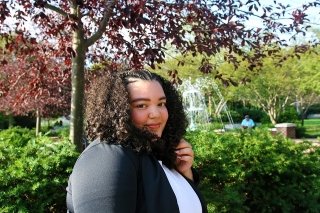 A girl in front of a fountain. 