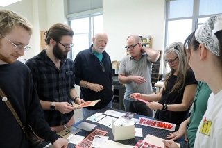 A group of people talking around a table. 