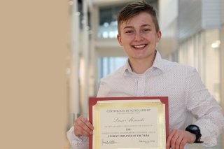 A person holding an award.