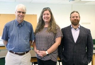 Two men and a woman standing between them. 