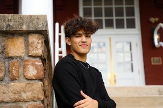 Randy Zea in a black shirt, leaning against a stone pole. 