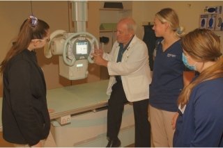 A group moving and looking at an x-ray tube. 