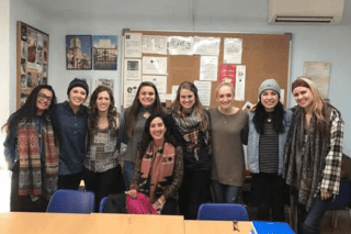 A group standing together in a classroom. 