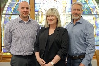 A group of three standing together. 