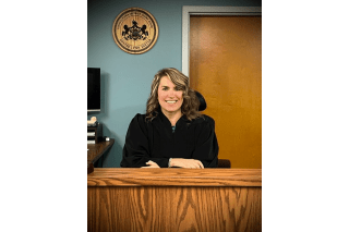 Female Judge behind a Judge Desk. 