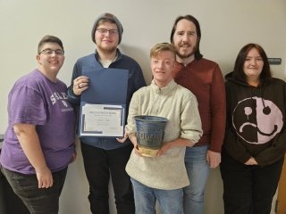 Group standing with an award. 