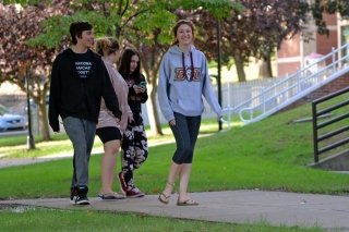 A group of people walking on the sidewalk. 