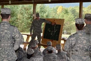 Military people looking at a board together. 