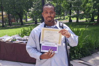 A man holding two awards. 