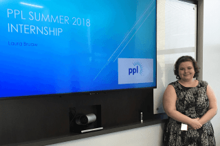 A woman standing next to a smart board. 