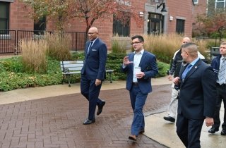 A group of people walking through campus together. 