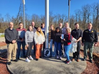 A group standing around a pole. 