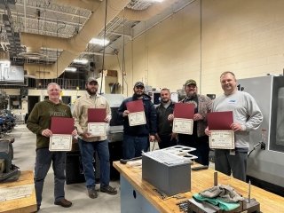 A group of people standing together with awards. 