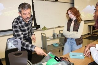 Two people standing together in a classroom. 