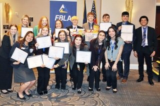 A group of people standing together with awards. 