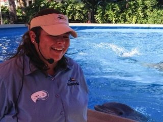 Katelynn Grabey in front of a pool of water in a SeaWorld uniform. 