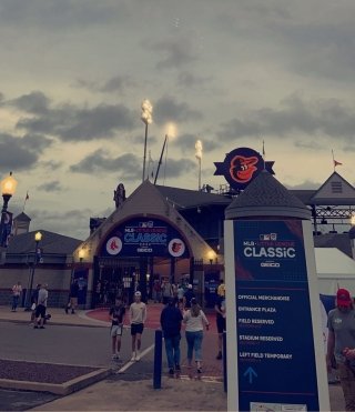 A group walking into a building next to a sign that says, "MLB CLASSIC"