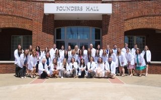 A group of students standing and sitting for a photo. 