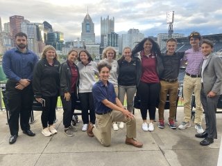 A group of people standing in front of a city outlook. 