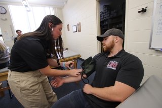 An Athletic Training training student at Commonwealth University Lock Haven practices taking another student's blood pressure