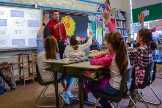 A CU-Lock Haven Mid Level Education major teaching division to a group of students with their hands raised