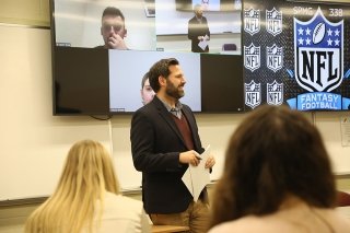 A CU faculty member teaches a Sport Management class to students in person and remotely