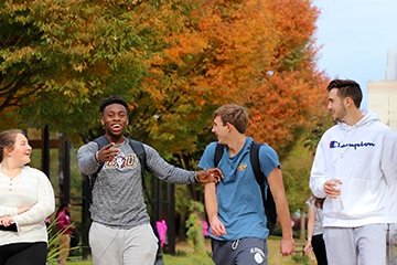 Students laughing and smiling as they walk on the Quad