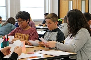 children reading in a classroom setting with a teacher guiding an activity