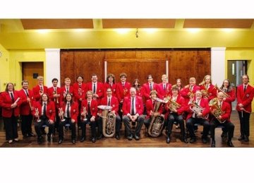 A band, wearing red, holding their instruments. 