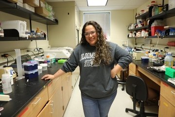 A girl standing in a lab setting. 