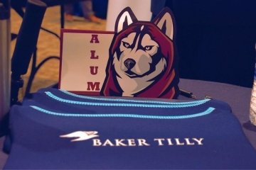 Baker Tilly Alum with a husky mascot sign. 