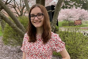 Megan Beck standing in front of a tree. 