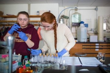 Two girls working together in a chemistry lab. 