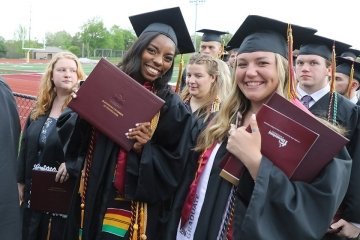 Students holding their diplomas. 
